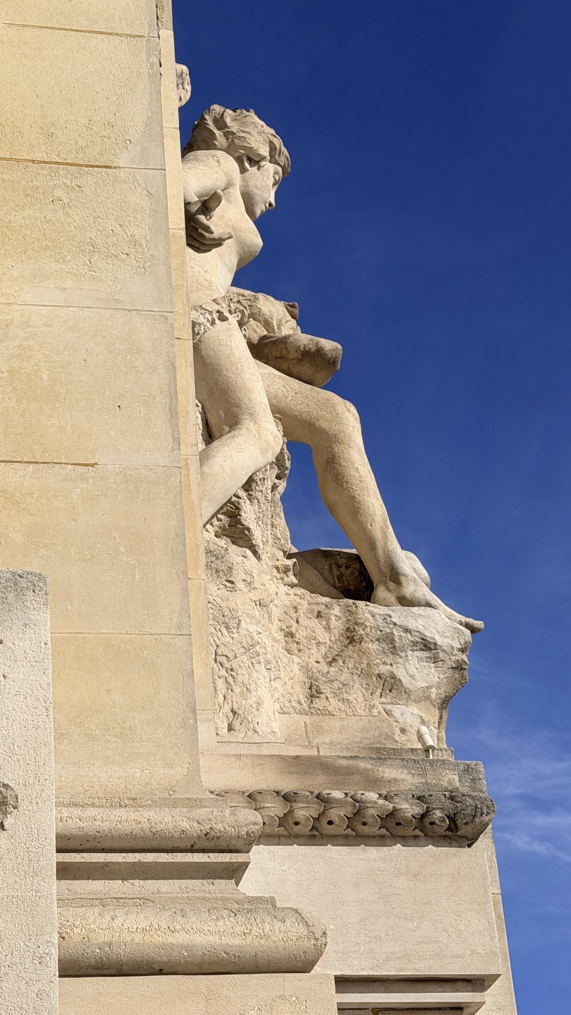 Sculpture de pierre en façade du Grand Palais, contre le ciel